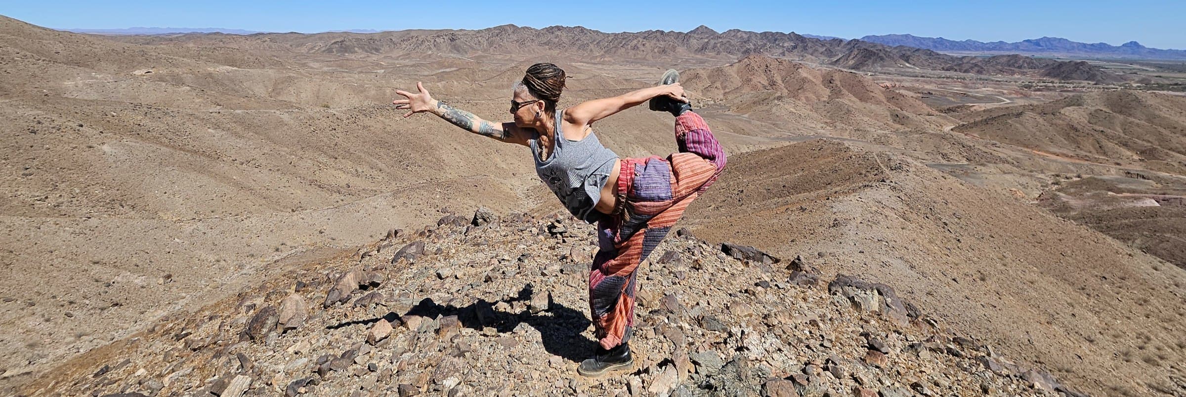 Lisa Rae Carroll in Dancer's pose on a desert ridge