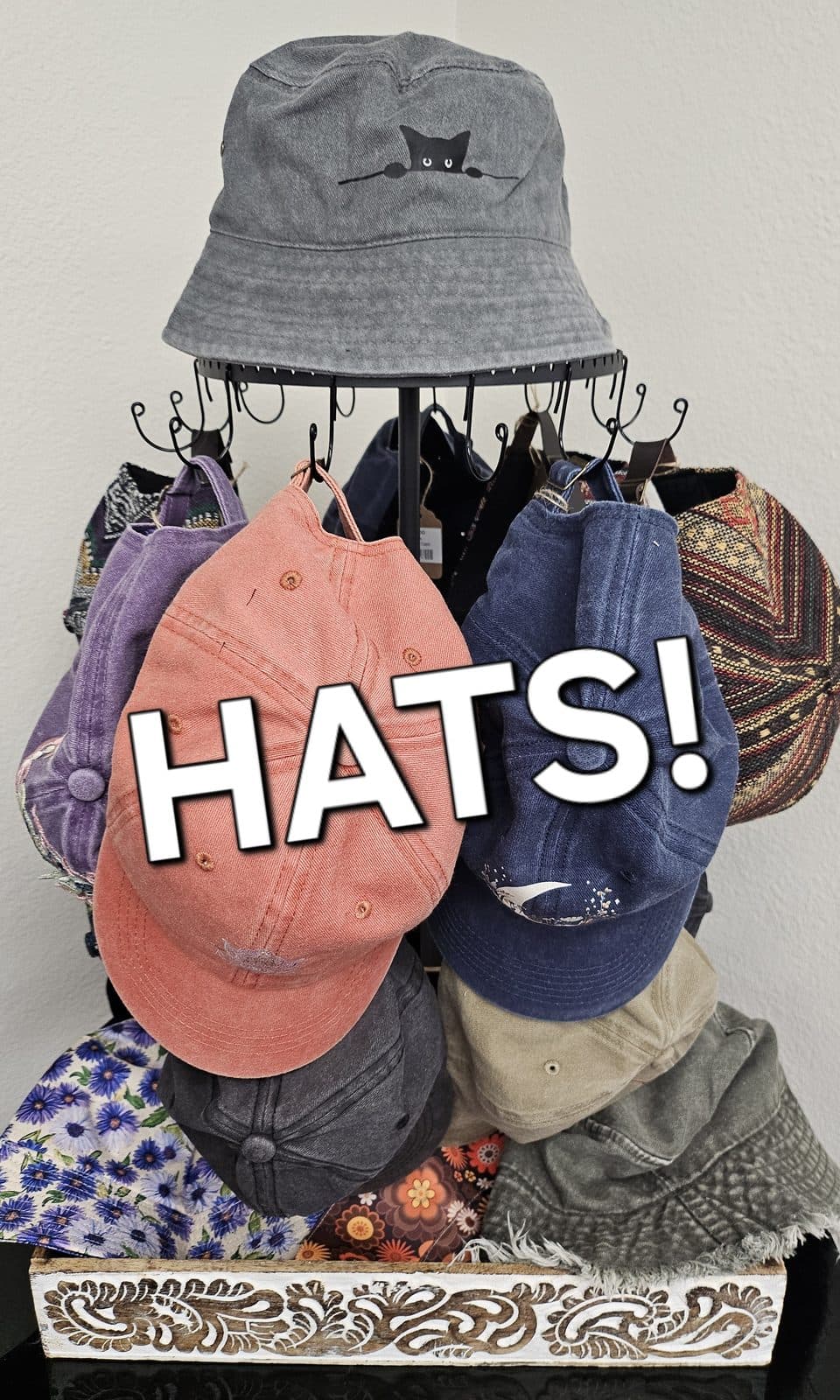 A rack of caps under a cat-face bucket hat, captioned “Hats!”.